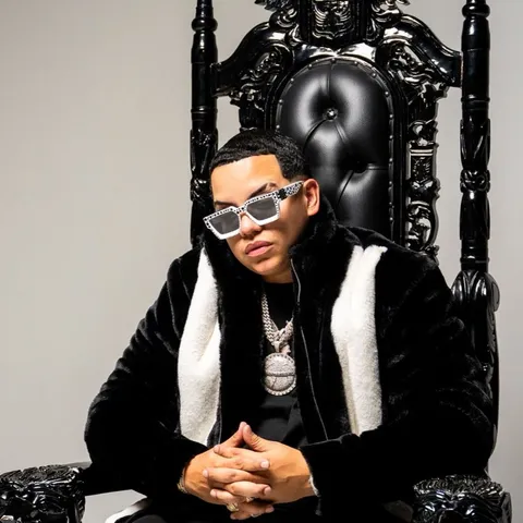 J Alvarez sitting on a black carved throne